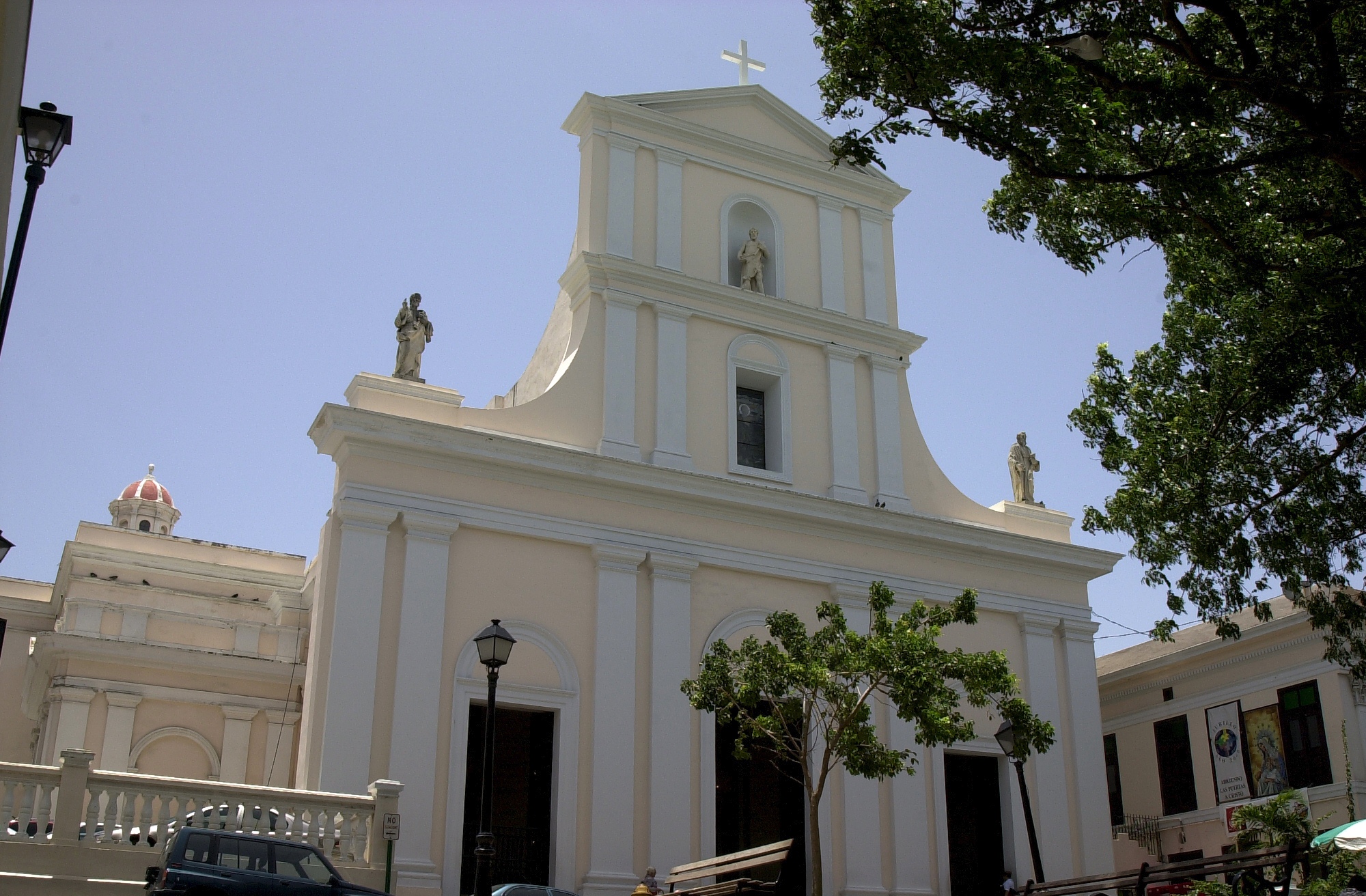 a white church with a steeple is pictured on a clear day