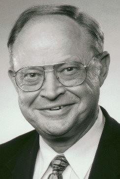 a man in glasses wearing a suit and tie