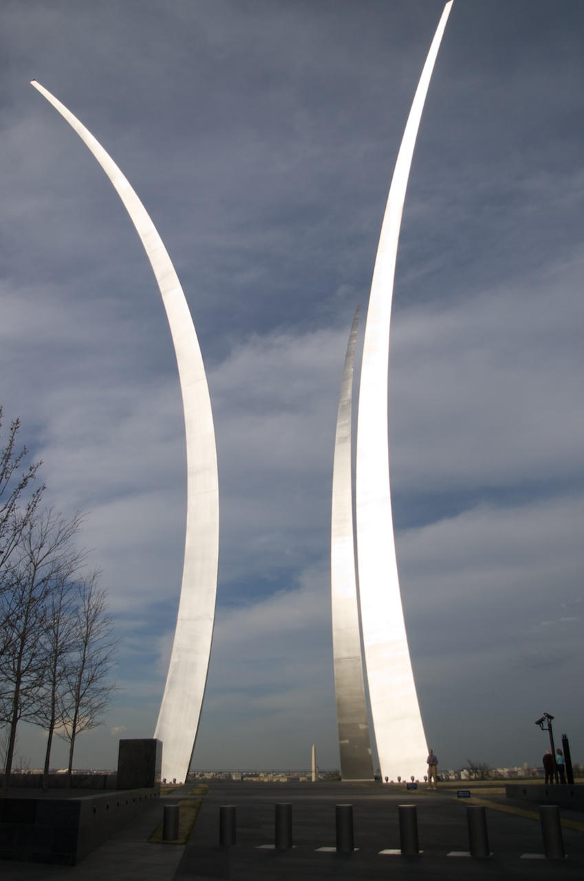 two long slender curved white metal statues