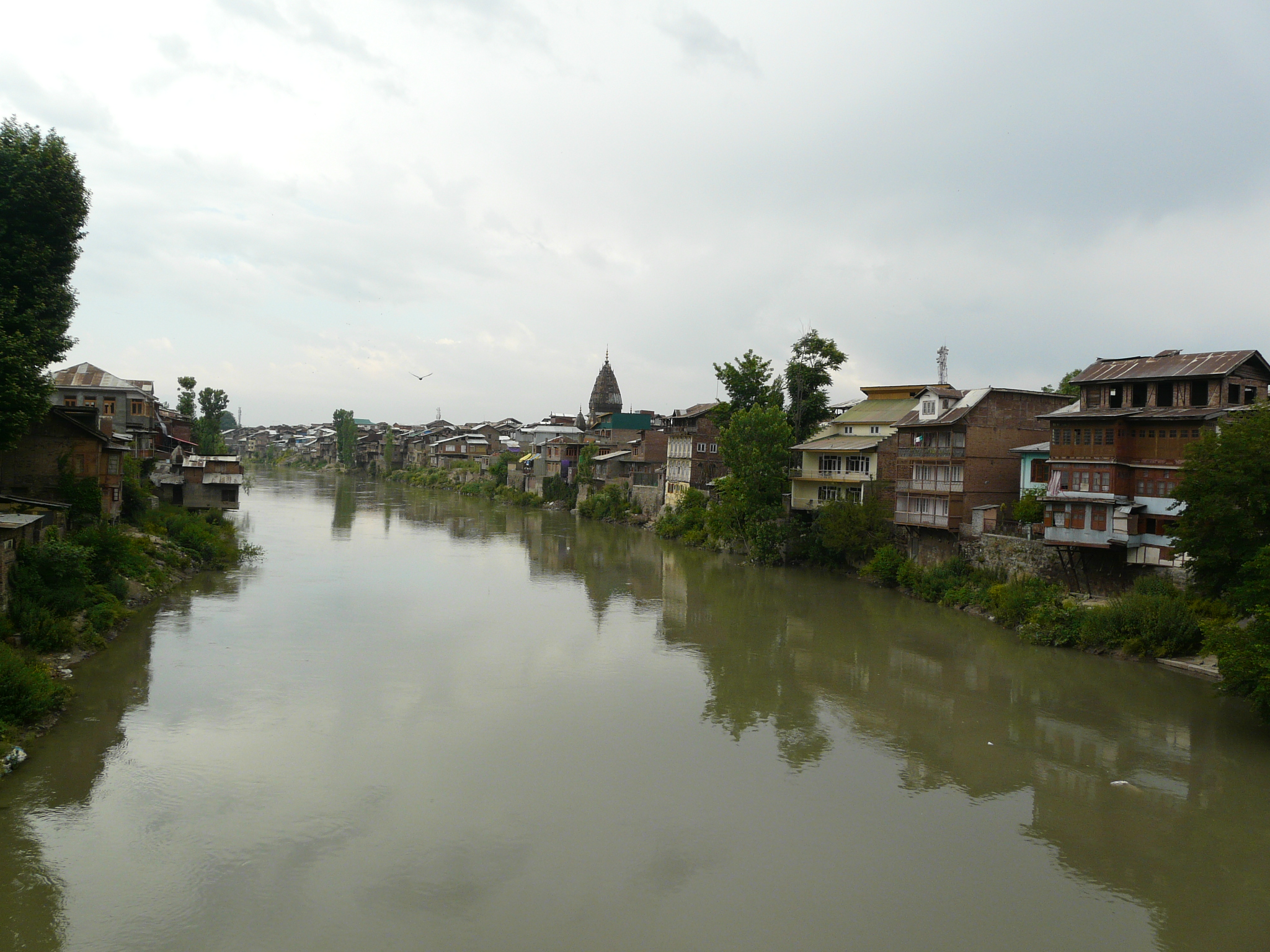 a river is bordered by many houses and trees
