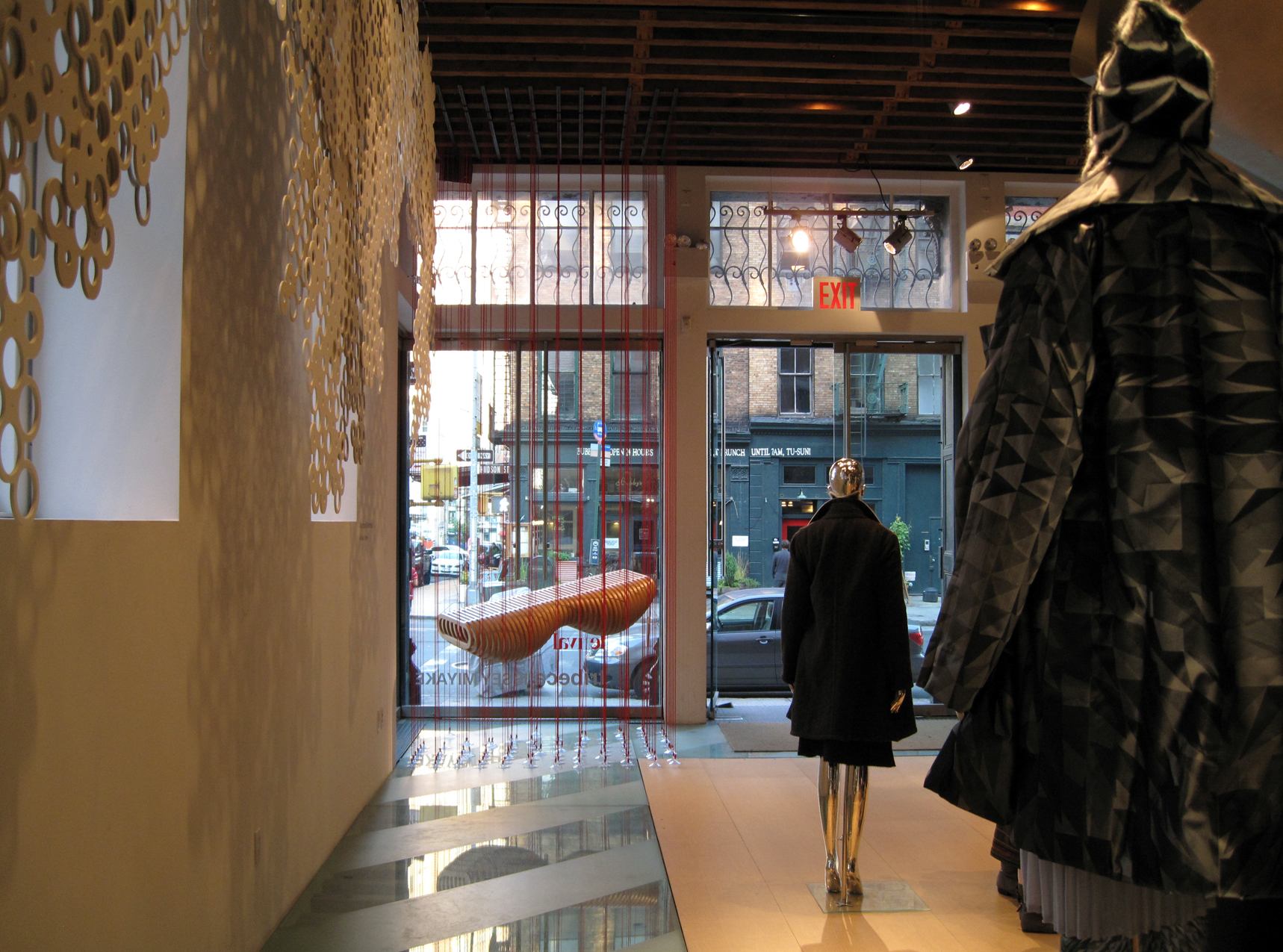 a woman walking by some mannequins in front of a building