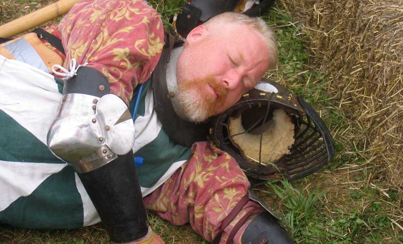 a man dressed in armor lies on the ground