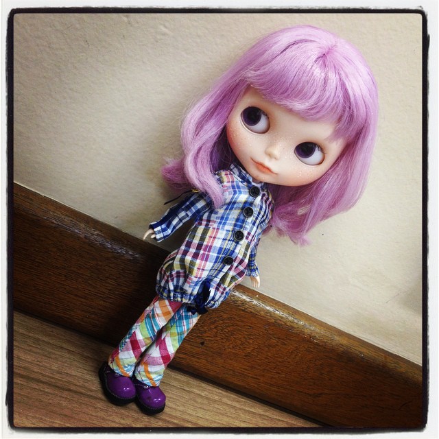 a purple haired doll with a plaid shirt and pants
