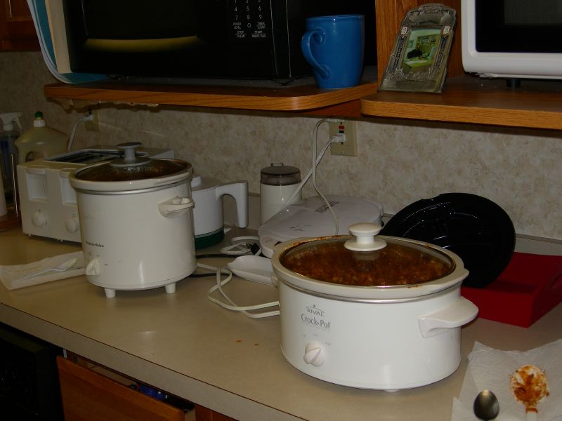 there are two crock pots on the kitchen counter