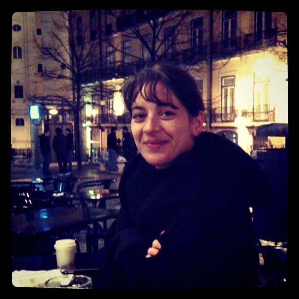 a woman sitting in an outdoor cafe with drinks