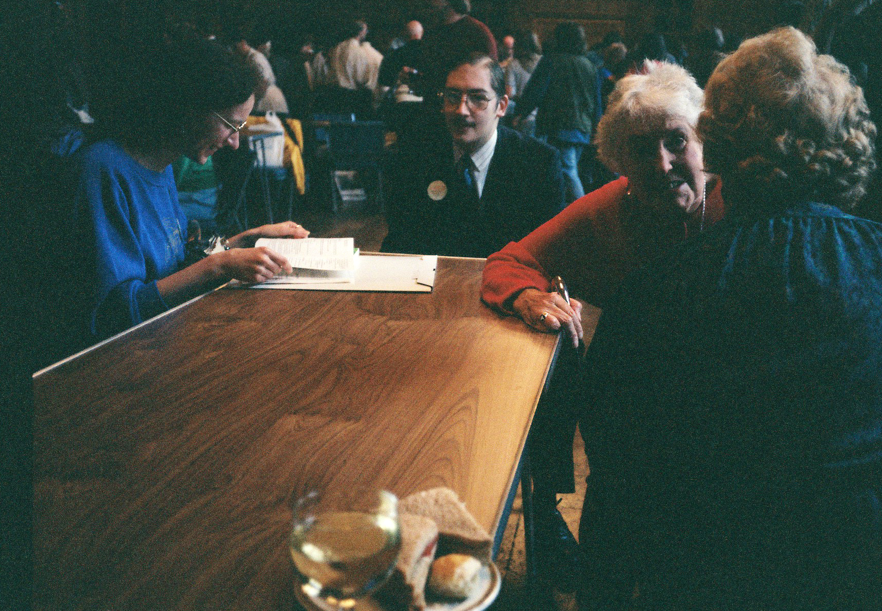 people sitting at wooden counter with notepads and glasses