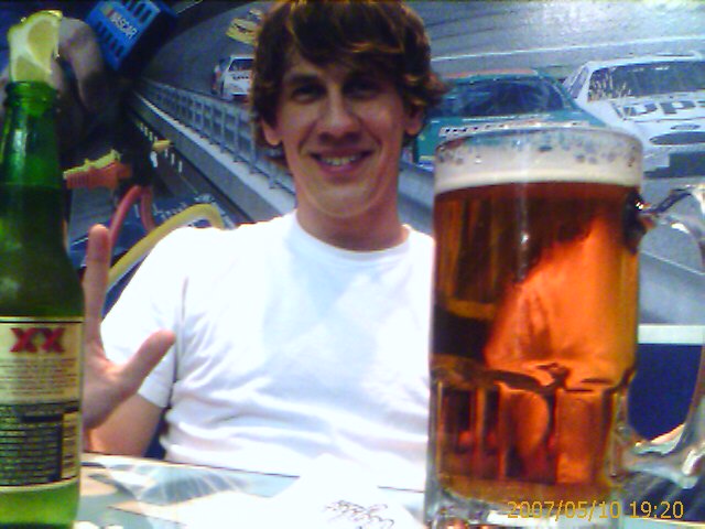 the man is smiling next to two glasses of beer
