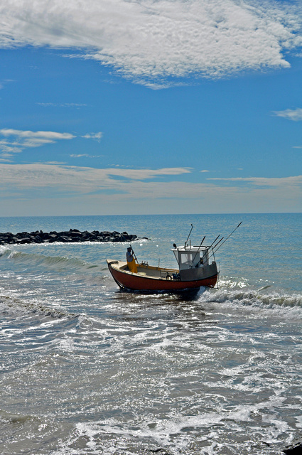 two boats sit on the beach at low tide