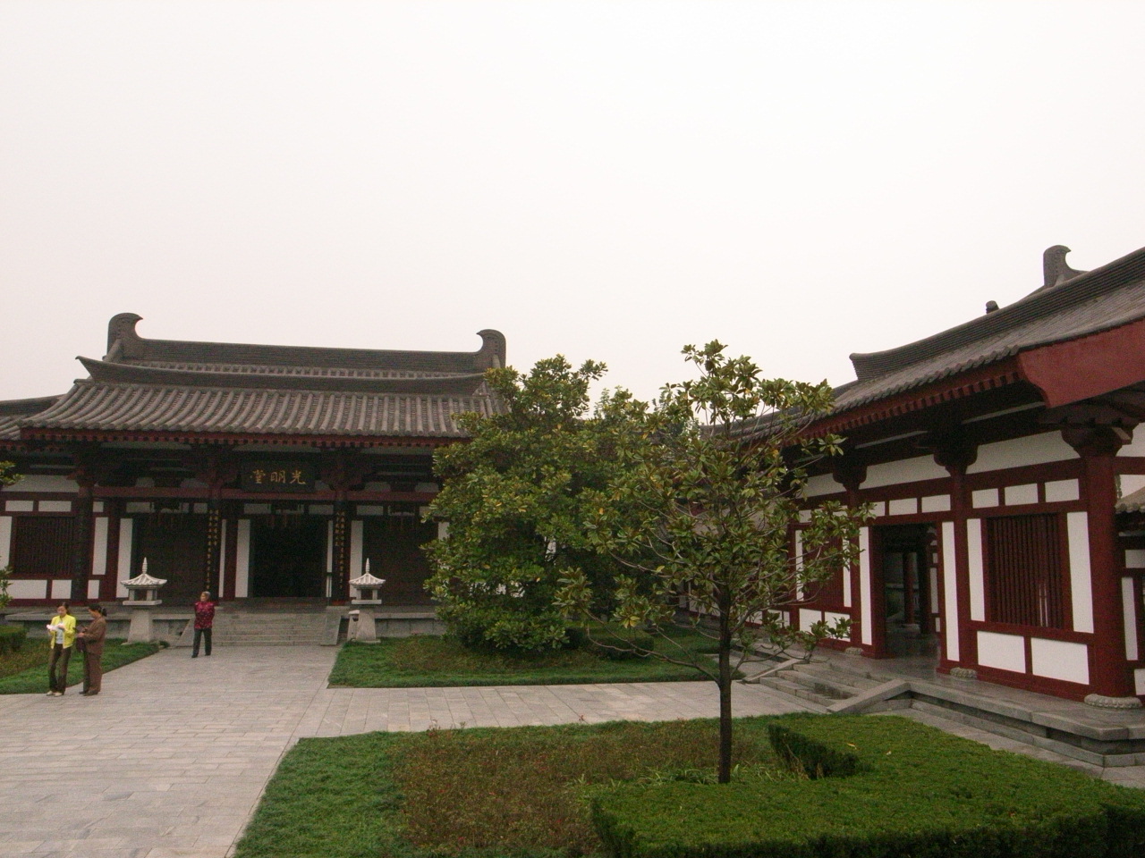 the courtyard of an ancient chinese building is seen with some grass and trees