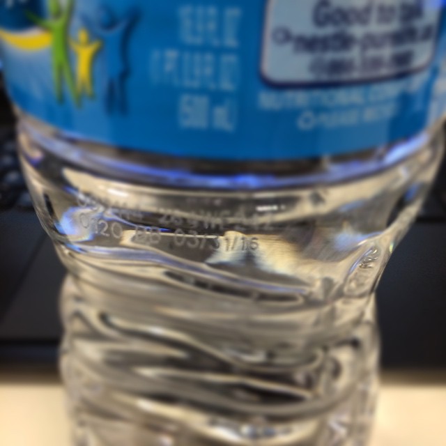 a close up of a bottle of water on a table