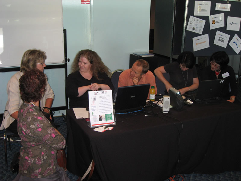 several people are gathered around laptops at a desk