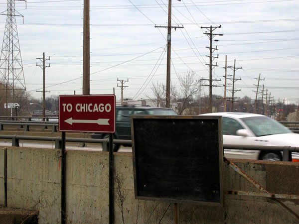 a traffic sign on the side of a road near cars