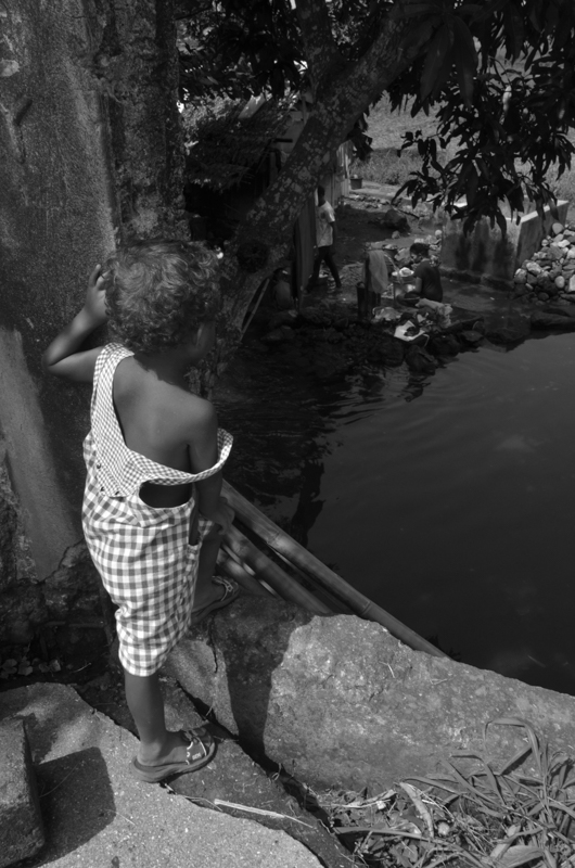 a black and white po of a small boy near the water