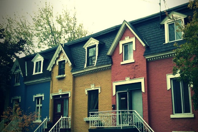 the front of a row of houses with multiple windows and doors