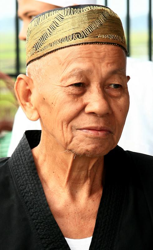 a older man wearing a yellow head cover