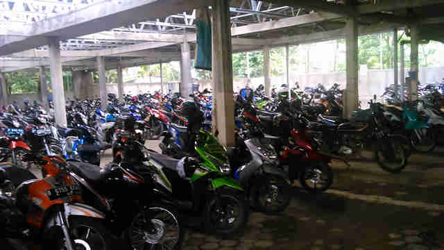 a room filled with many parked motorcycles in a parking lot