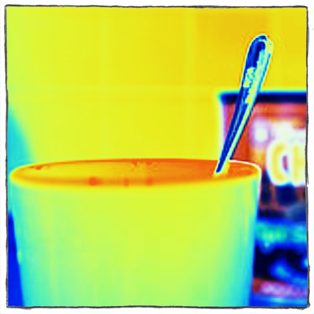 a black toothbrush resting in an orange cup