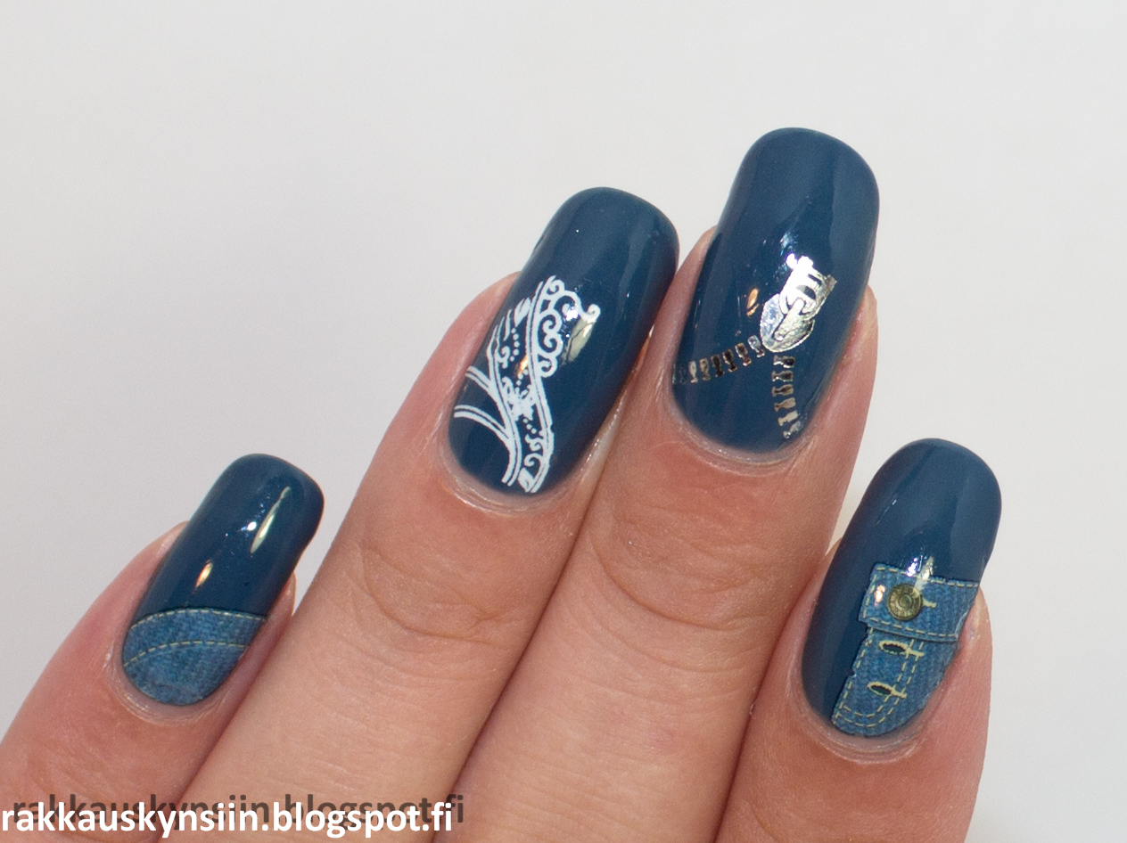 a hand with blue nail polish and decorative stamping