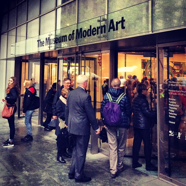 people are walking into the museum of modern art