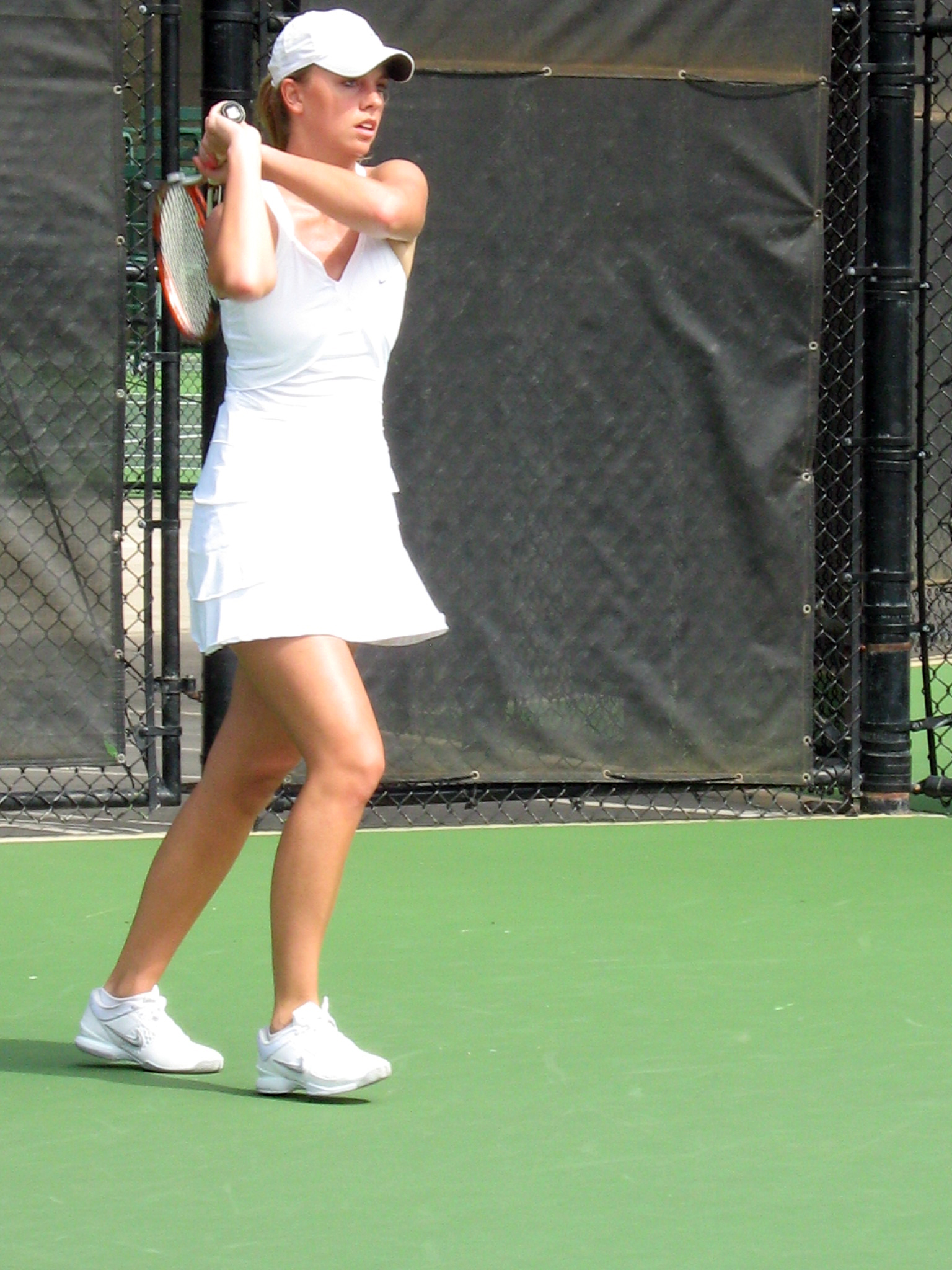 a woman in white is playing tennis and wearing white