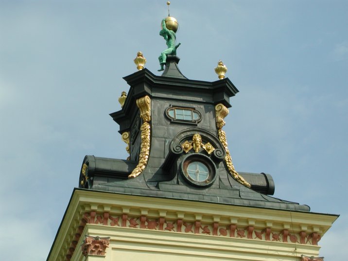 an ornate clock tower that has gold ornaments on it