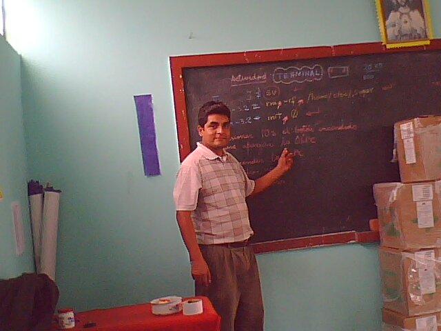 a man stands next to a chalk board in front of boxes
