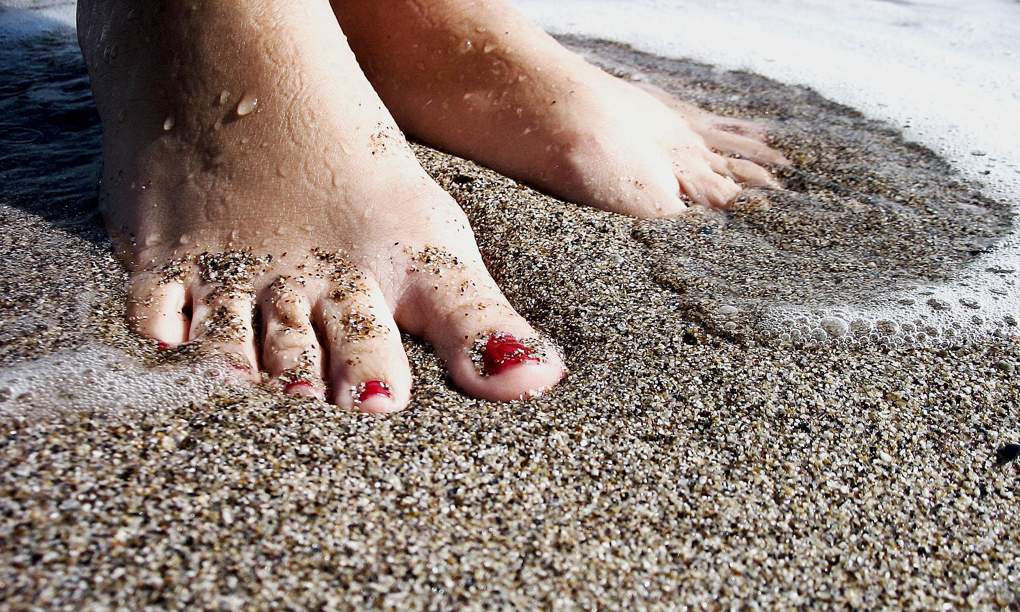 a foot is buried in sand at the beach