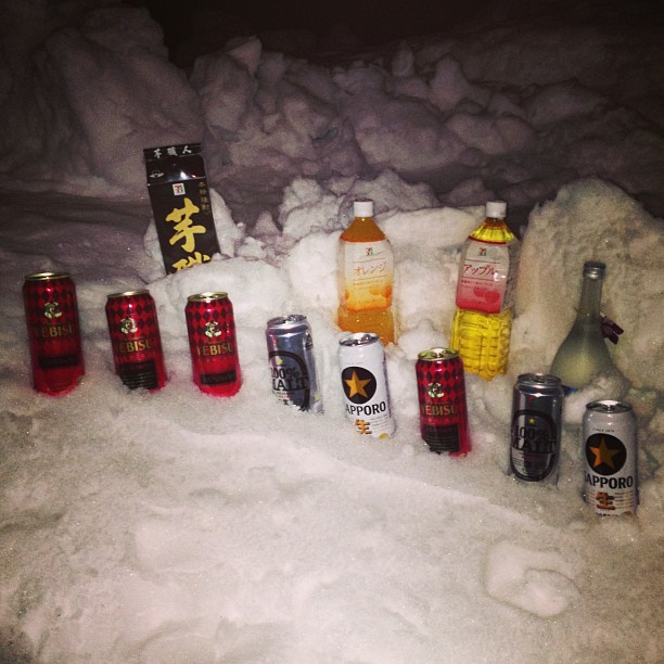 several bottles and cans lie covered in snow