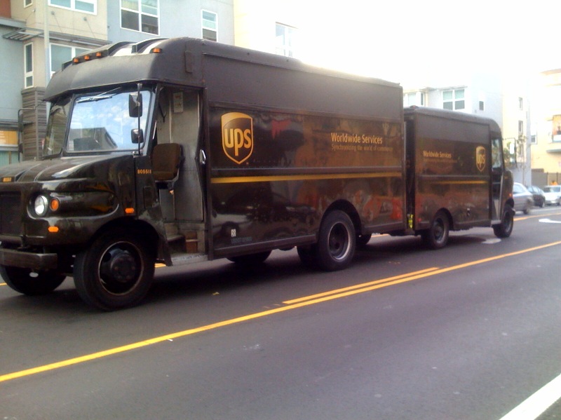 a ups truck driving down the road in traffic