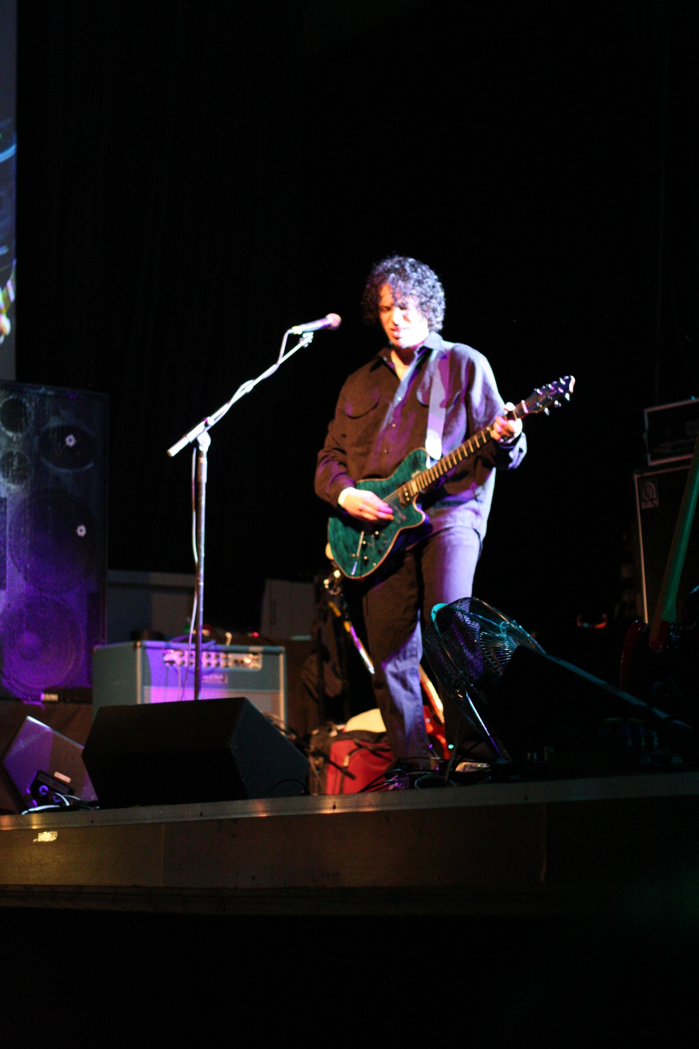 a man playing the guitar while performing on stage