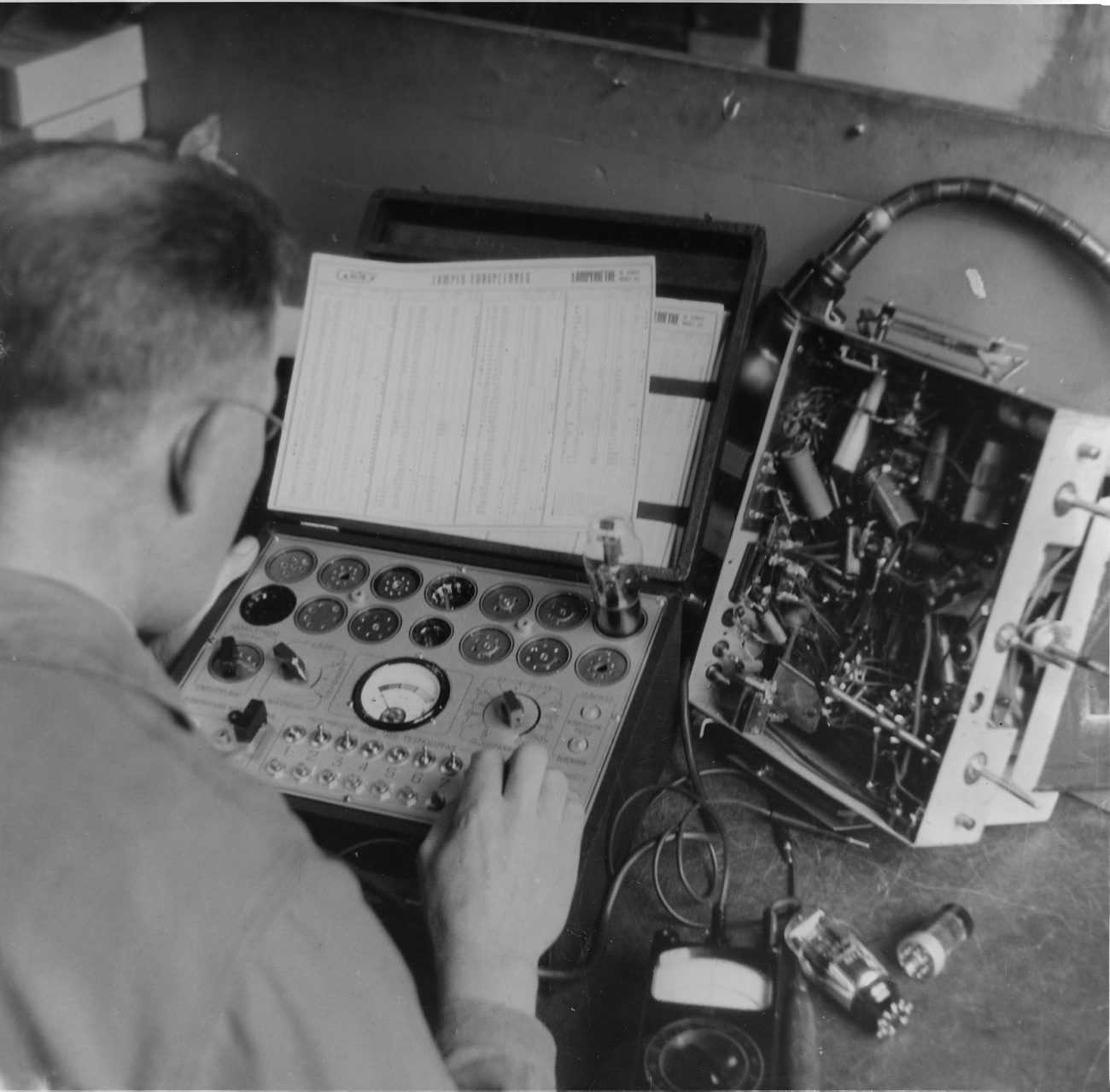 a man with an old fashioned radio working on a machine