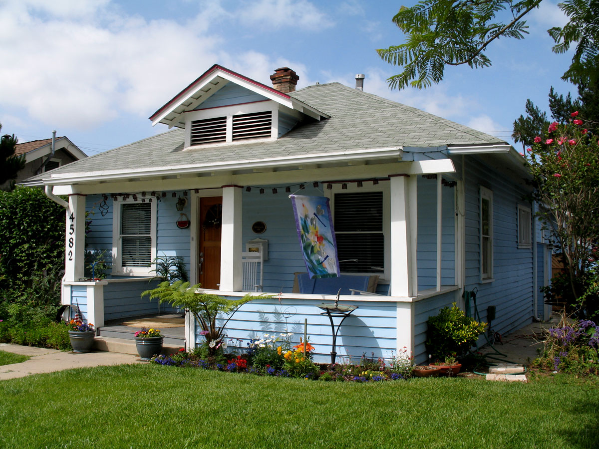 a small home with a lawn and green lawn