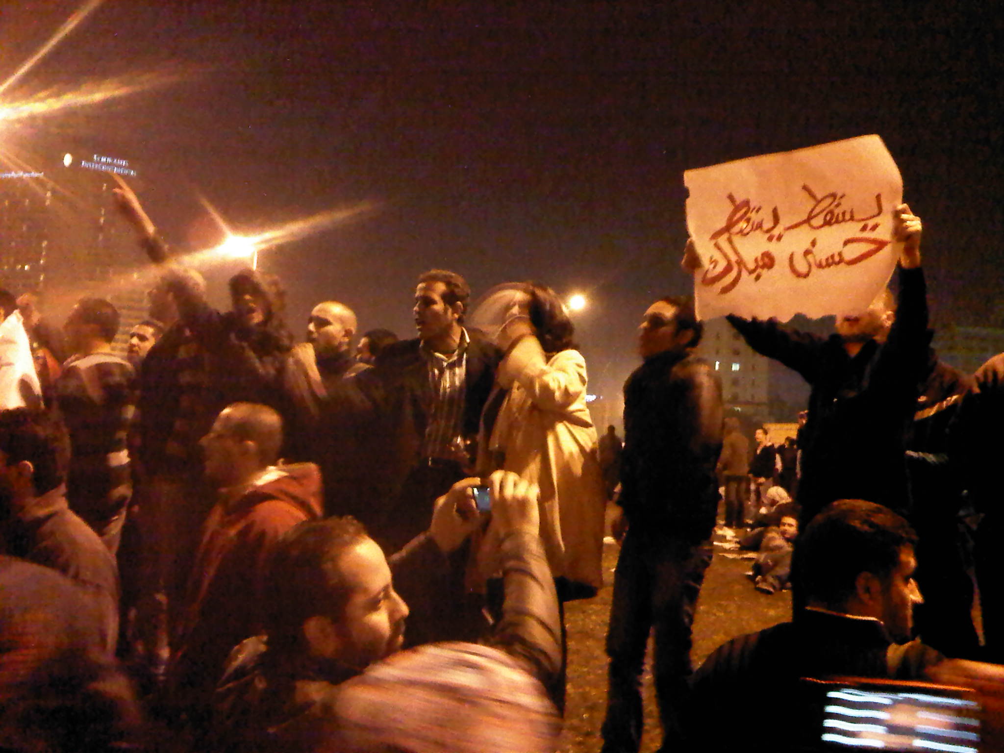 many people standing in the street holding up signs