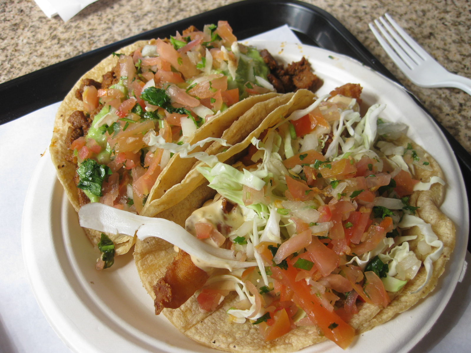 a plate topped with a taco and two tacos