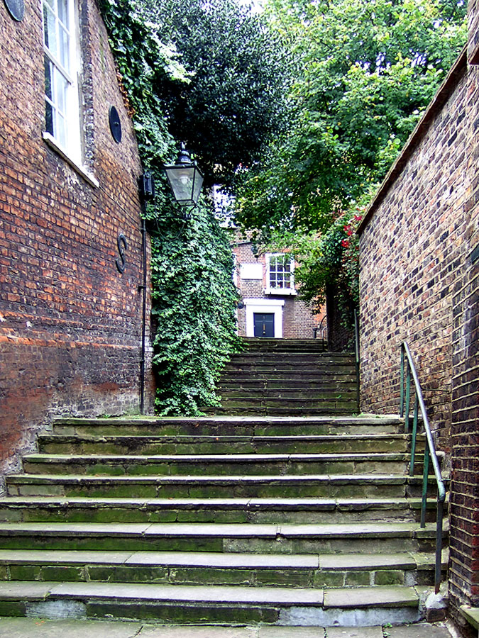 an old set of stairs going up to brick buildings