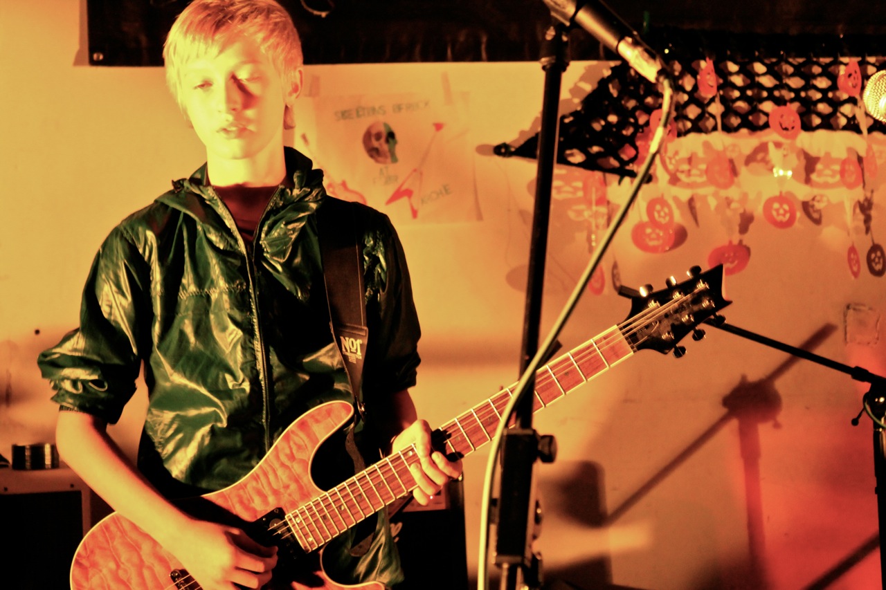 a boy playing a guitar in front of a microphone