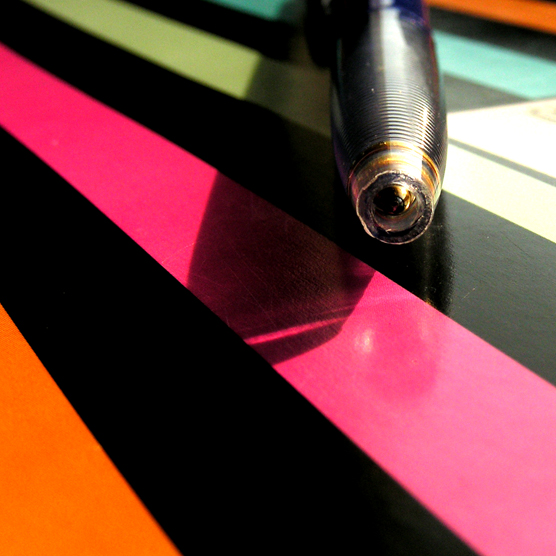 a close up of a pen on a striped table