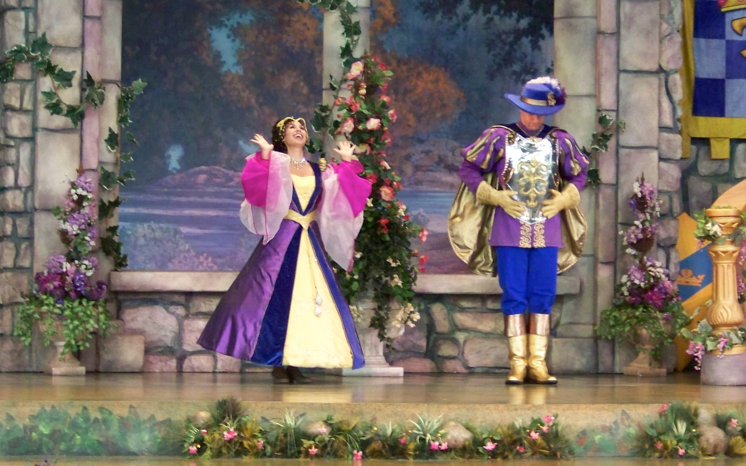 two actors wearing fancy clothes while performing on stage