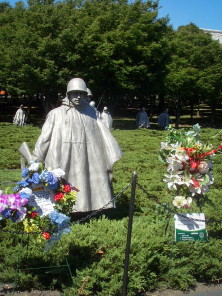 the statue and wreaths are covered with flowers