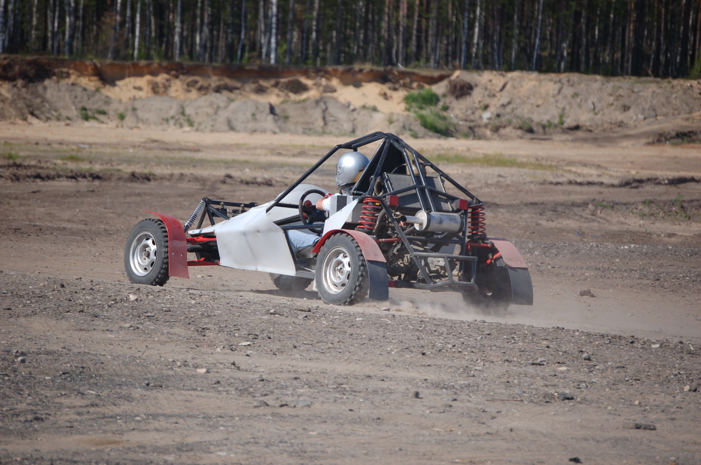 a man driving a small quad dune buggy