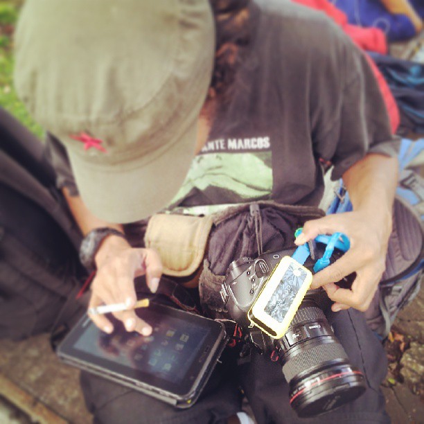 the pographer is holding his tablet next to his camera