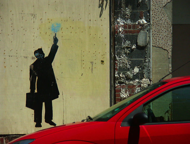 a street view with a person holding up a piece of blue light