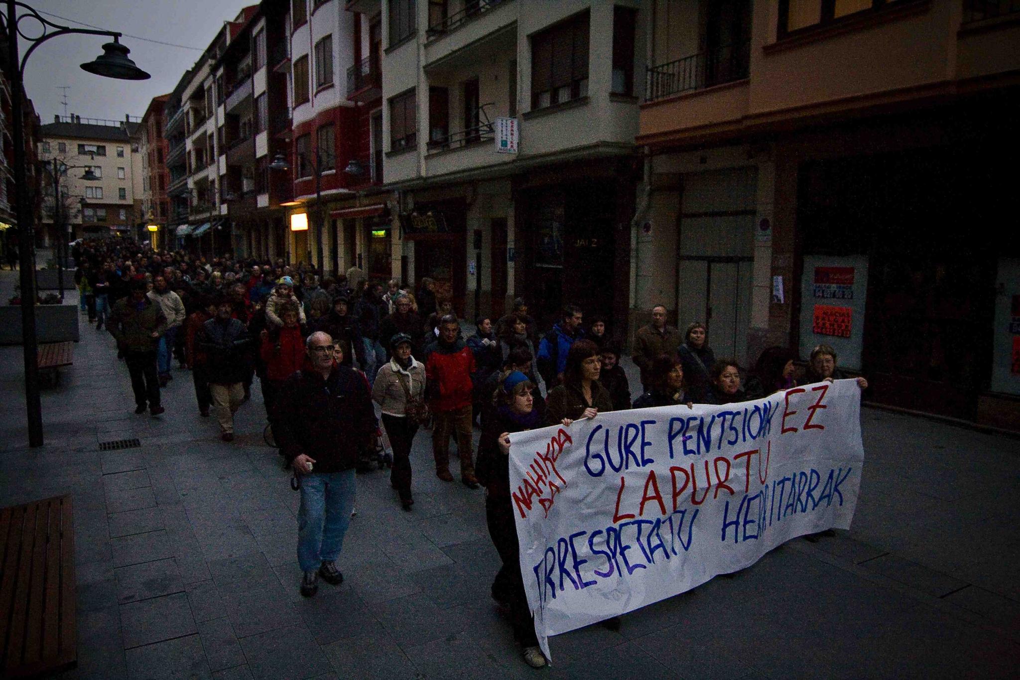 people walking down the street holding a sign