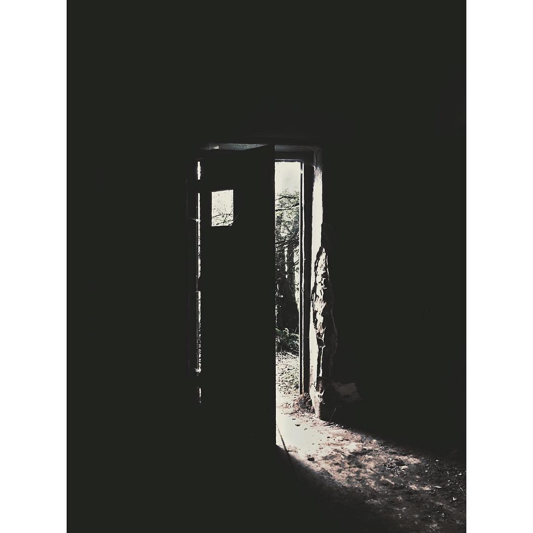 a door sitting in the dark of night with a doorway open