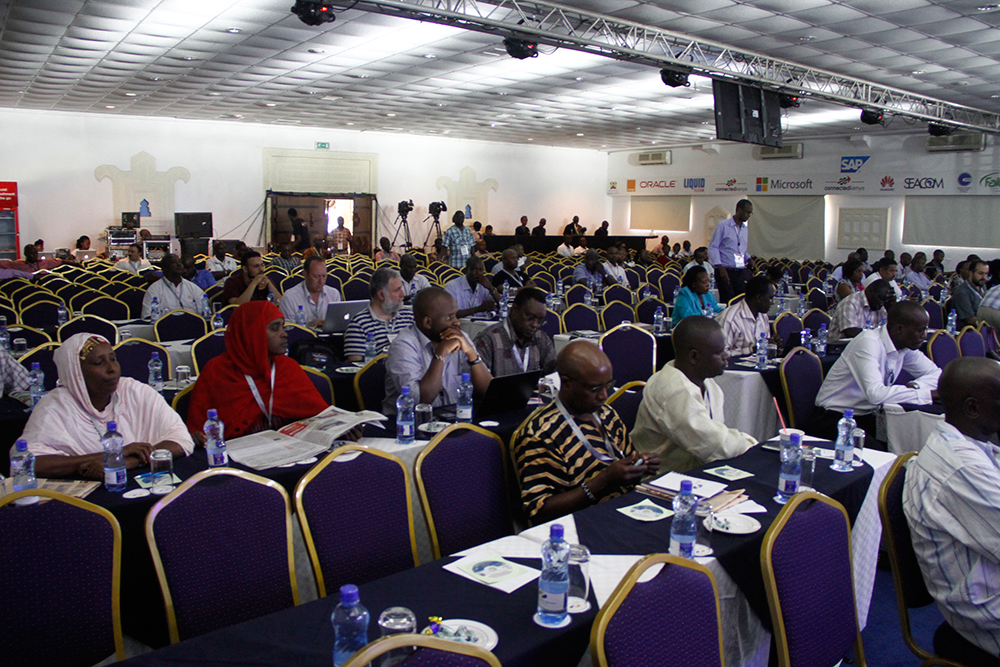 a number of people sitting in a room with many tables