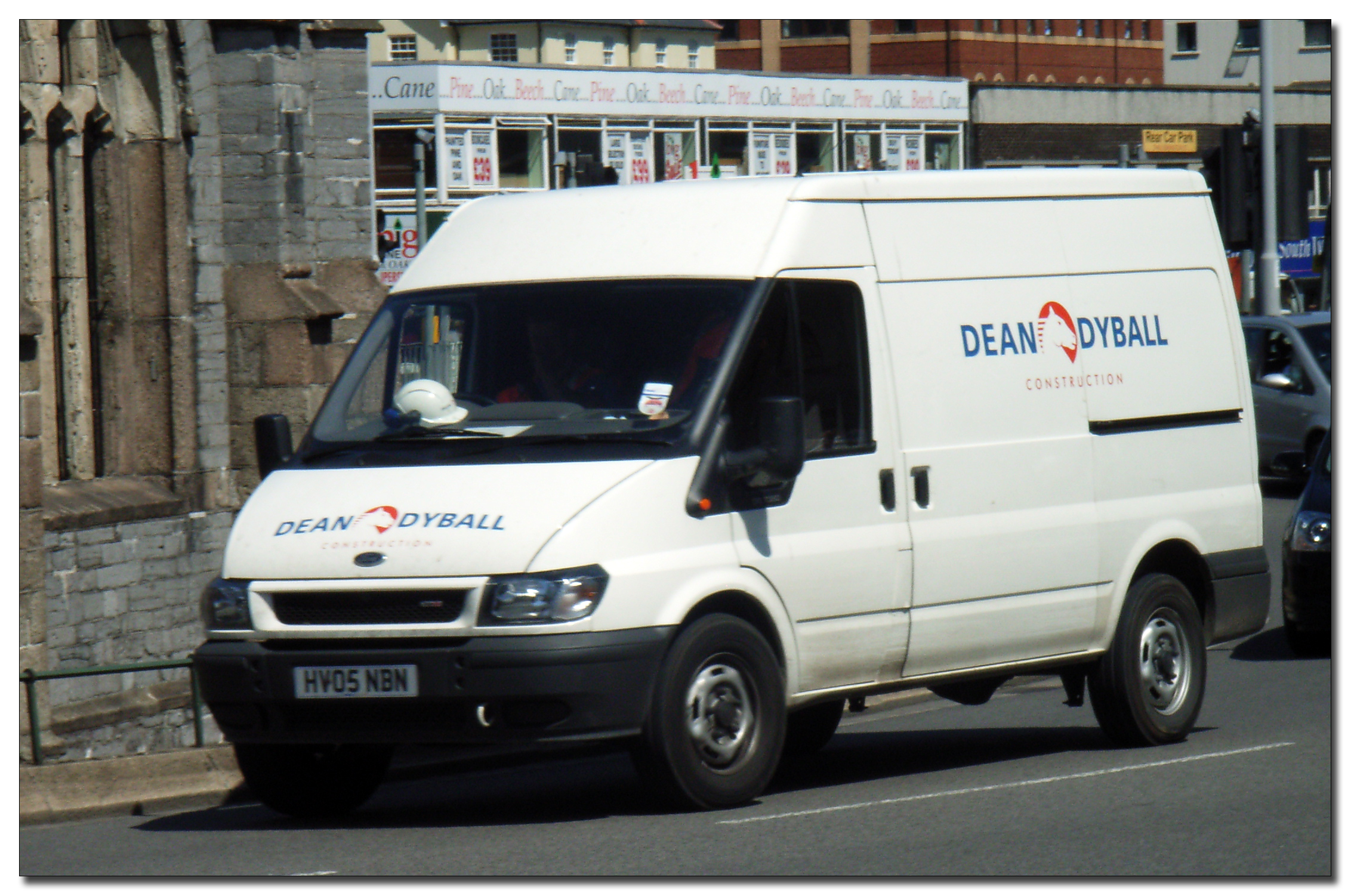 an delivery van on a street in front of brick building