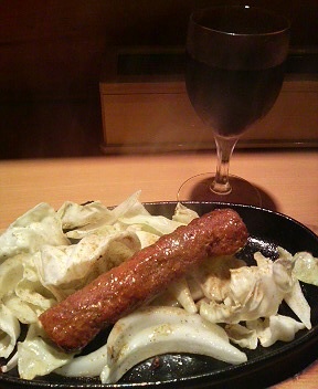 a sausage that is on a plate with some cabbage