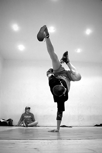 a person wearing pants doing a hand stand on one leg