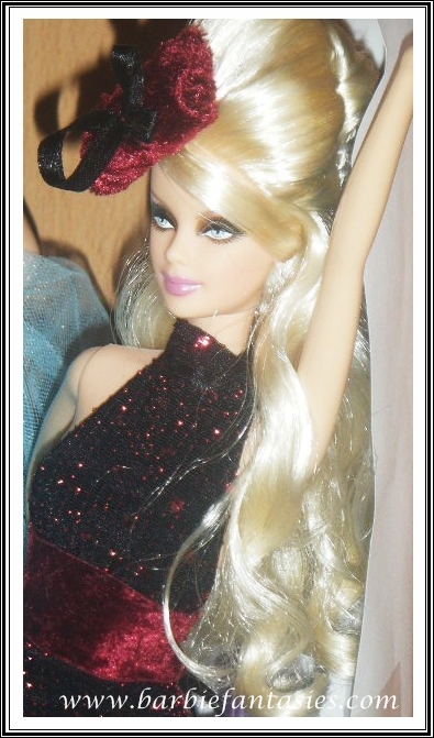 a close up of a doll wearing a dress and headband