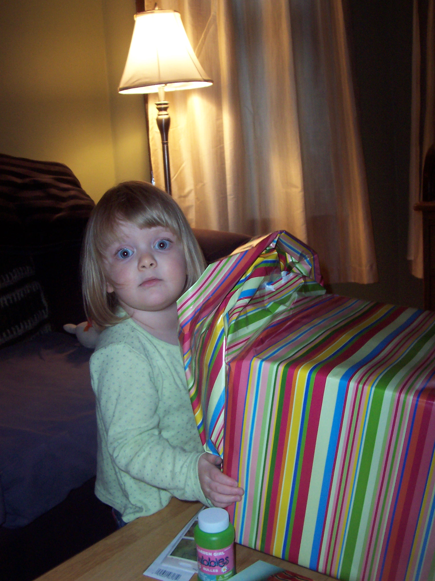 a small girl sitting with a bag on her lap